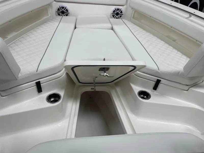 Slide: The Image of 2024 Pursuit S 248 Sport boat interior with white cushioned seating and storage compartment. - 17