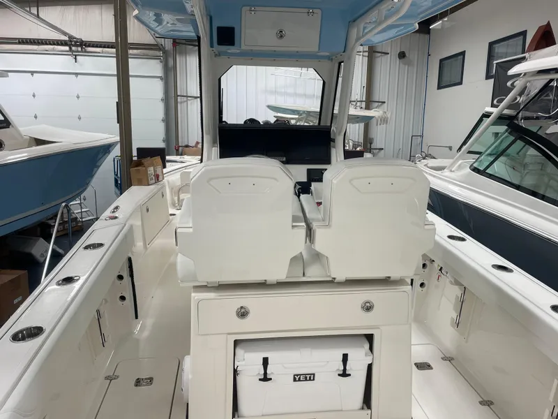 Slide: The Image of 2024 Pursuit S 248 Sport boat interior with dual seats and Yeti cooler. - 3