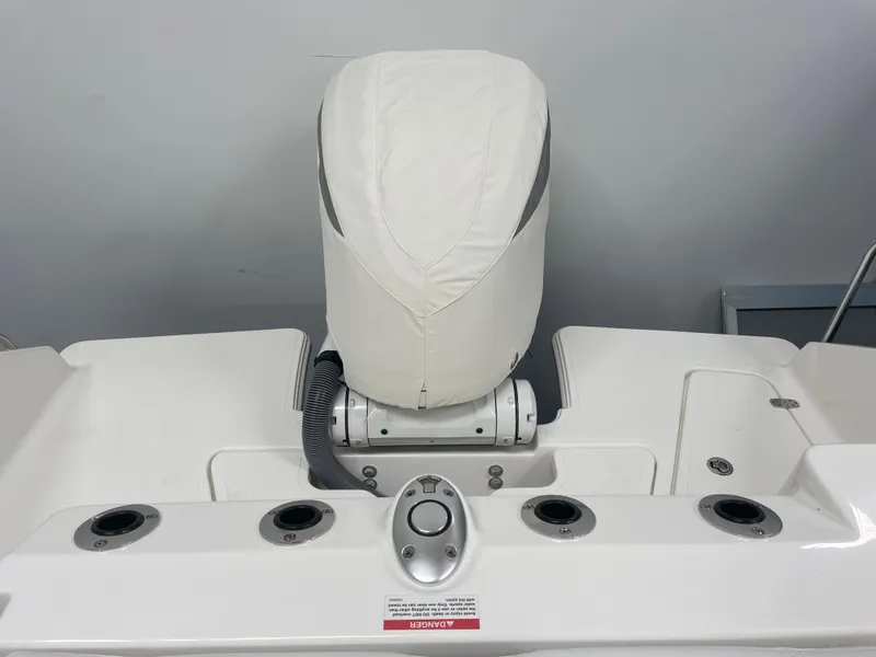 Slide: The Image of 2024 Pursuit S 248 Sport boat engine with cover and rod holders. - 4