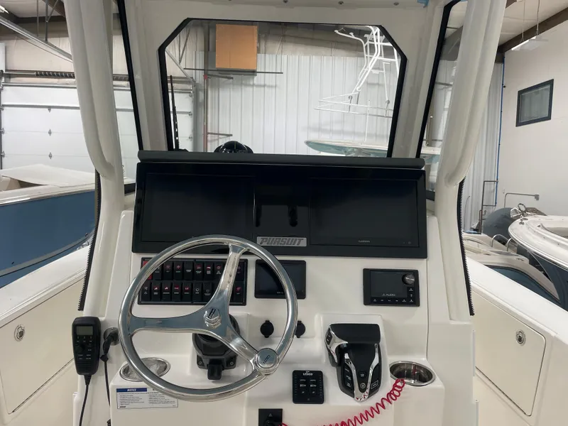 Slide: The Image of 2024 Pursuit S 248 Sport boat dashboard with steering wheel and control panel. - 6