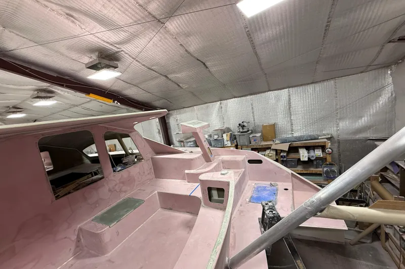 Slide: The Image of 2026 Schionning Arrow 1280 S catamaran under construction in a workshop. - 108
