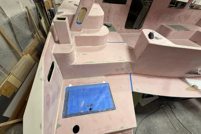 Slide: The Image of 2026 Schionning Arrow 1280 S catamaran under construction, showcasing unfinished deck details. - 110