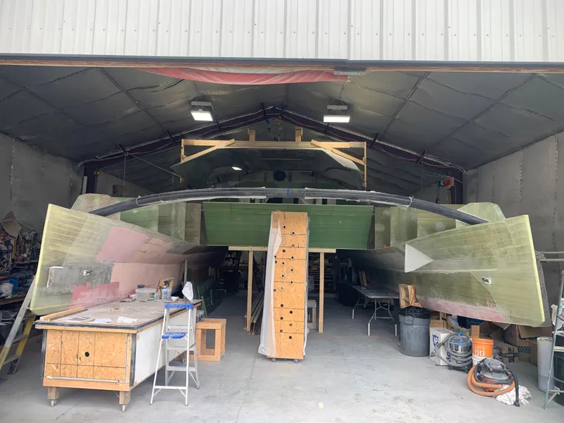 Slide: The Image of 2024 Schionning Arrow 1280 S catamaran under construction in a workshop. - 15