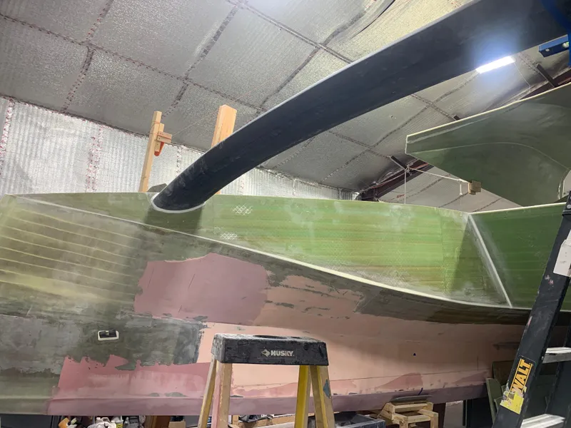 Slide: The Image of 2024 Schionning Arrow 1280 S catamaran under construction in a workshop. - 18