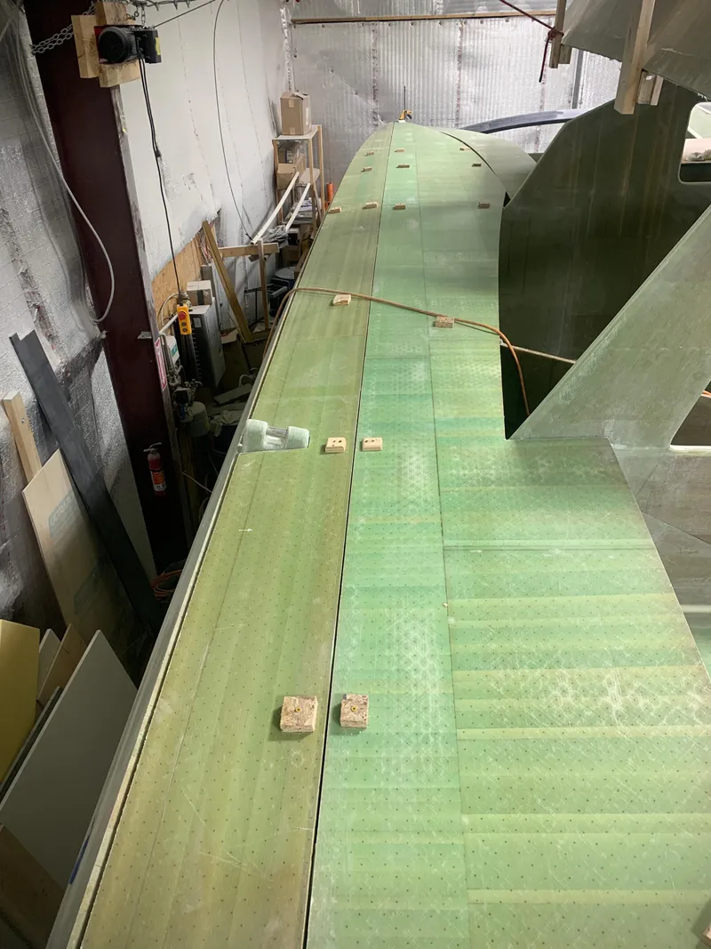 Slide: The Image of 2024 Schionning Arrow 1280 S catamaran under construction in a workshop. - 27