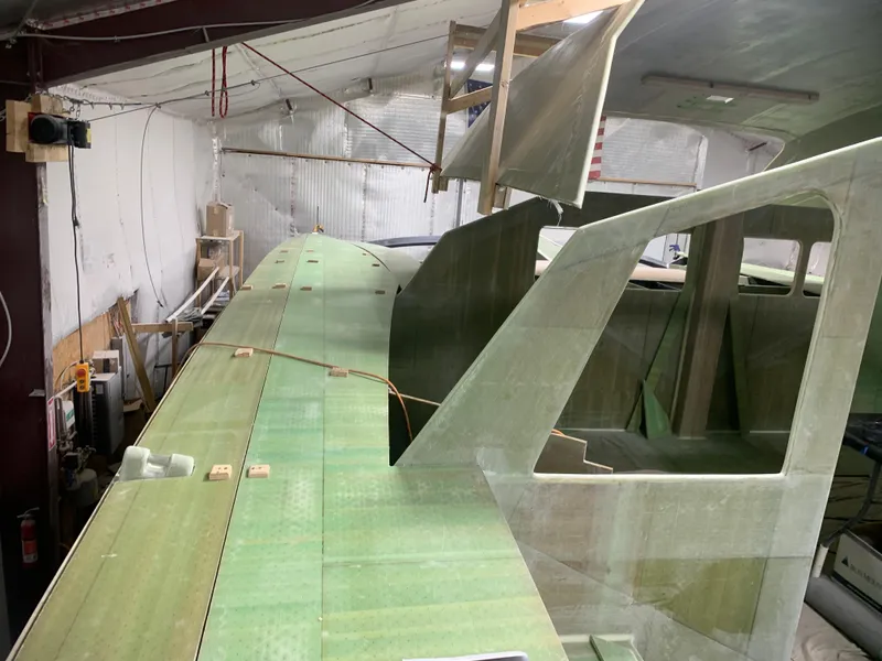 Slide: The Image of 2024 Schionning Arrow 1280 S catamaran under construction in a workshop. - 28