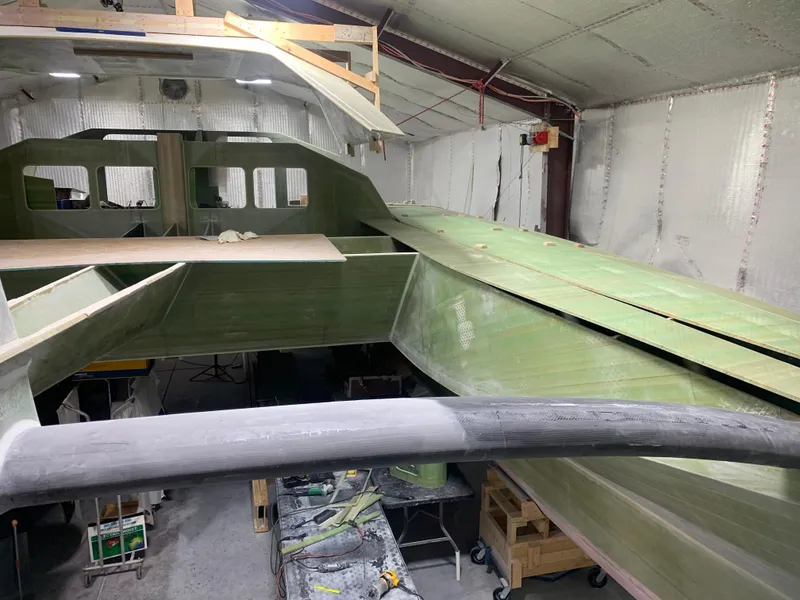 Slide: The Image of 2024 Schionning Arrow 1280 S catamaran under construction in a workshop. - 30