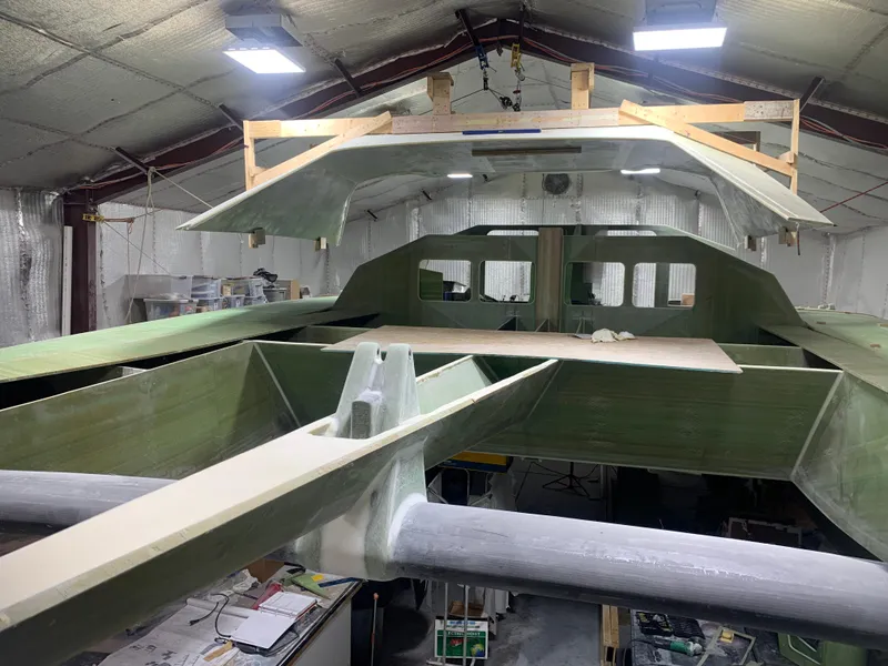 Slide: The Image of 2024 Schionning Arrow 1280 S catamaran under construction in a workshop. - 31