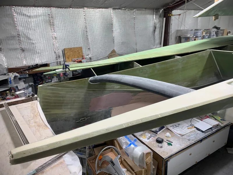 Slide: The Image of 2024 Schionning Arrow 1280 S catamaran under construction in a workshop. - 32