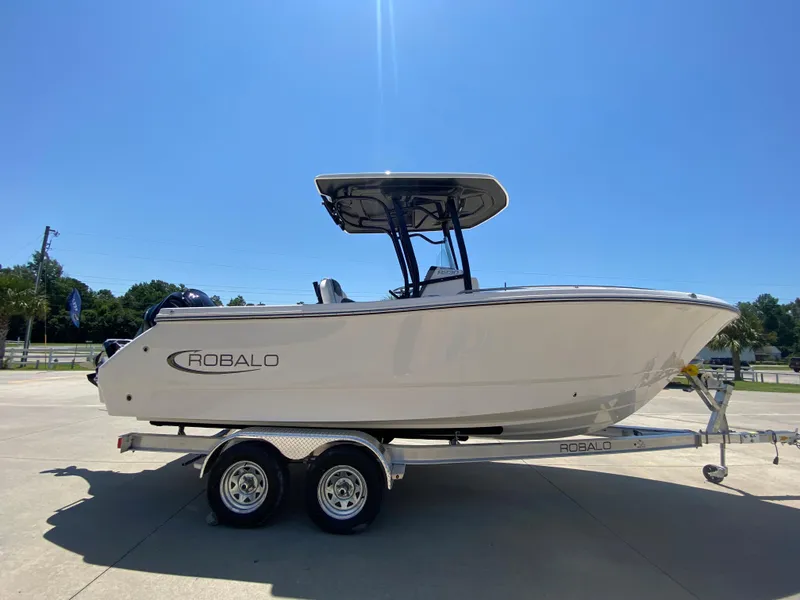 Slide: The Image of 2024 Robalo R230 Center Console boat on a trailer under clear blue sky. - 3