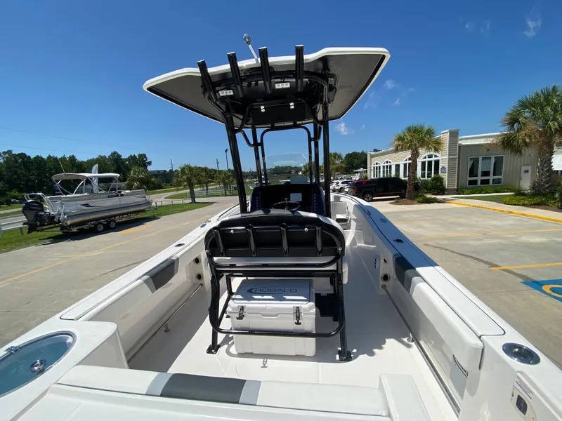 Slide: The Image of 2024 Robalo R230 Center Console boat with T-top and seating, parked outdoors. - 6