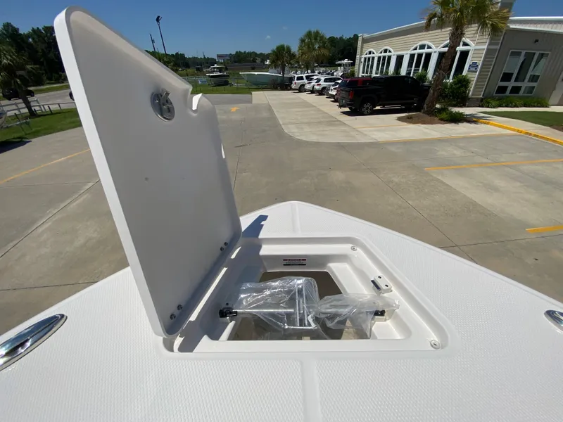 Slide: The Image of 2024 Robalo R230 Center Console boat storage compartment open in a dealership lot. - 25