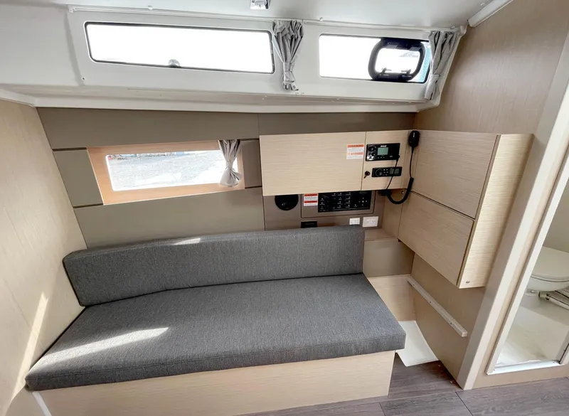 Slide: The Image of 2024 Beneteau Oceanis 38.1 interior with gray seating and control panel. - 11
