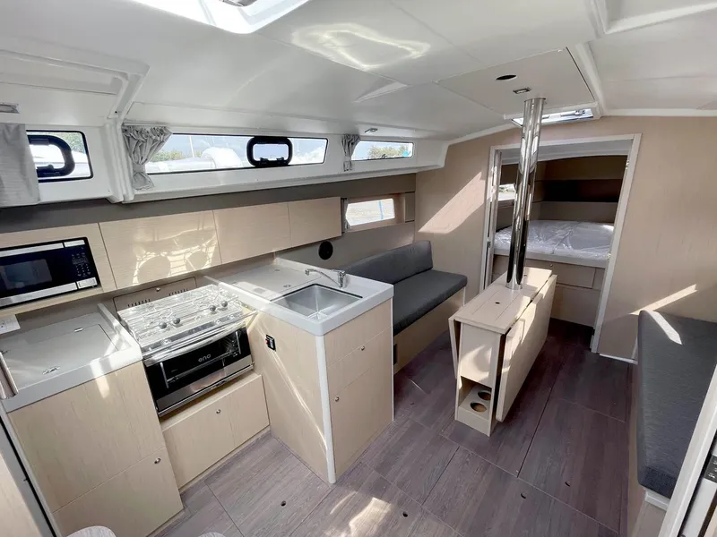 Slide: The Image of 2024 Beneteau Oceanis 38.1 interior with modern kitchen and cozy seating area. - 13