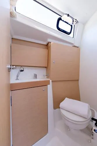 Slide: The Image of 2024 Beneteau Oceanis 38.1 bathroom with modern fixtures and natural wood cabinetry. - 15