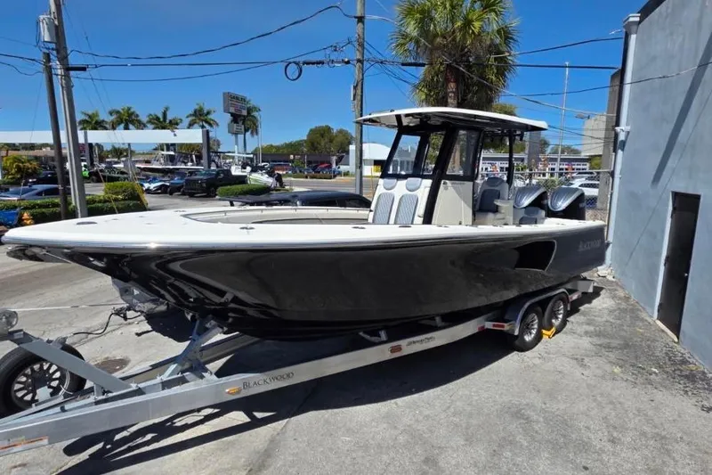 Slide: The Image of 2024 Blackwood 290 boat on trailer, parked outdoors under clear blue sky. - 0