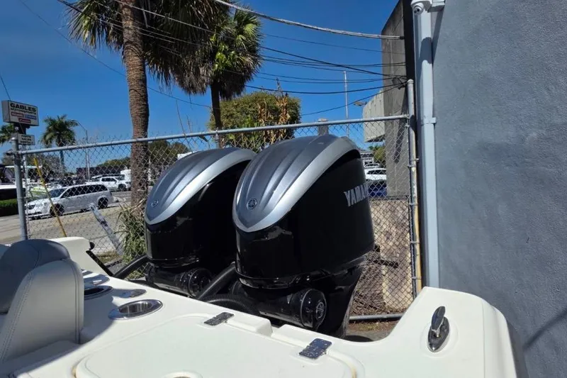 Slide: The Image of 2024 Blackwood 290 boat with dual Yamaha outboard engines, parked near a fence. - 12