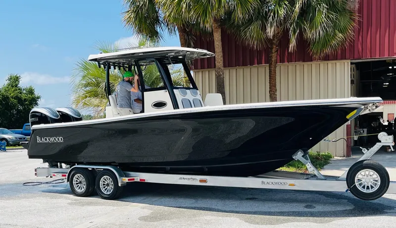 Slide: The Image of 2024 Blackwood 290 boat on trailer outside warehouse. - 2