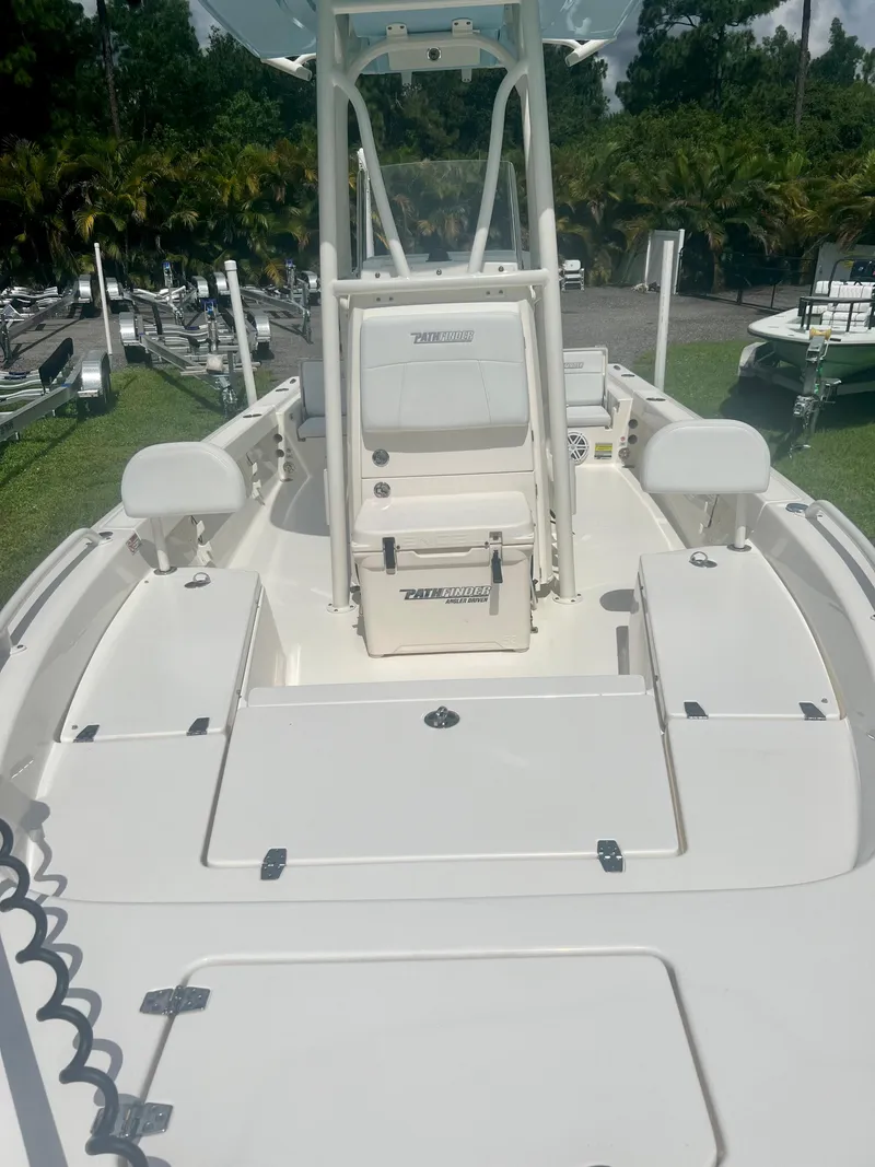 Slide: The Image of 2020 Pathfinder 2200 TRS boat with white deck and seating, parked on grass. - 14