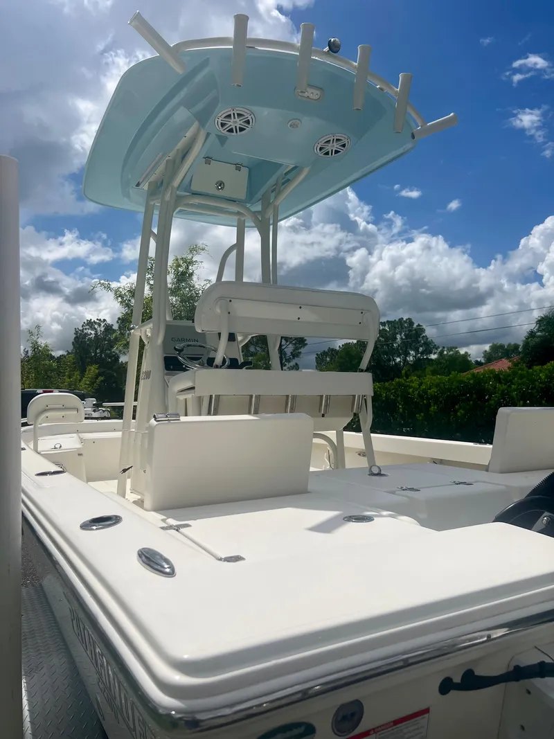 Slide: The Image of 2020 Pathfinder 2200 TRS boat with T-top and seating, under a partly cloudy sky. - 15