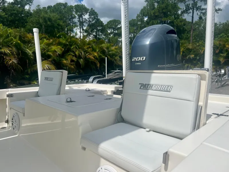 Slide: The Image of 2020 Pathfinder 2200 TRS boat with Yamaha 200 engine, white seating, and lush background. - 16