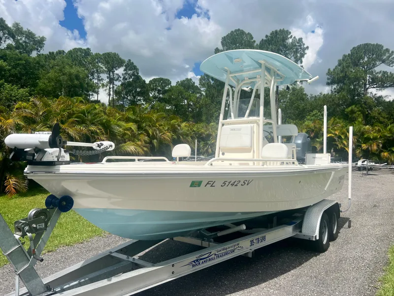 Slide: The Image of 2020 Pathfinder 2200 TRS boat on a trailer in a lush outdoor setting. - 2