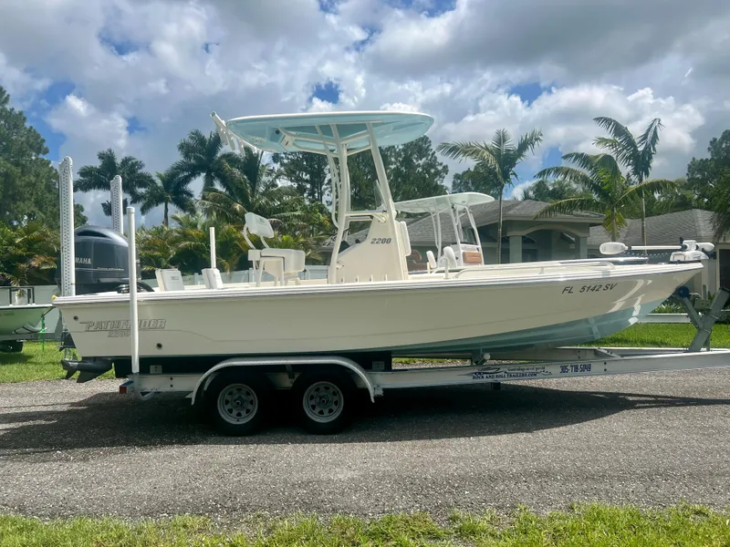 Slide: The Image of 2020 Pathfinder 2200 TRS boat on a trailer, parked outdoors with palm trees in the background. - 3