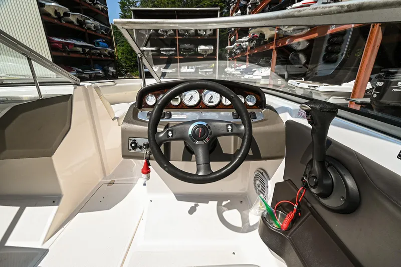 Slide: The Image of 2006 Regal 2000 Bowrider boat cockpit with steering wheel and control panel. - 16