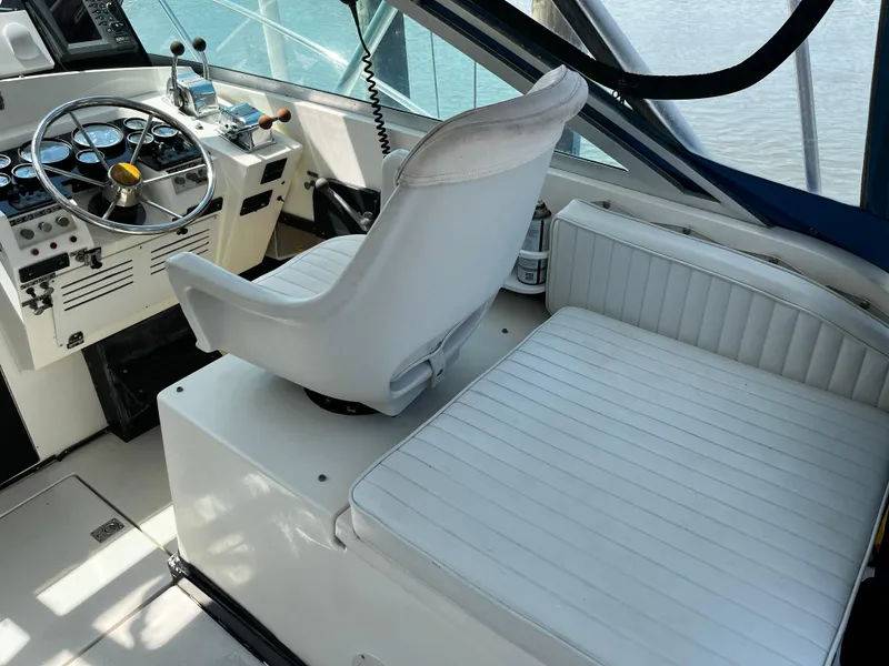 Slide: The Image of 1988 NorthCoast 24 Express Sportfish helm with white seating and control panel. - 22