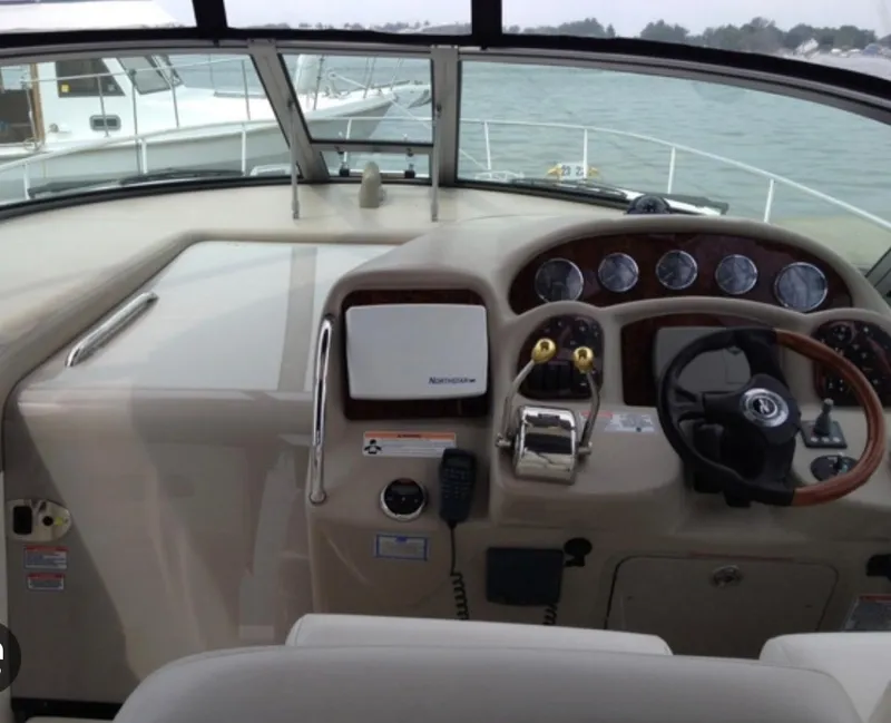 Slide: The Image of 2007 Sea Ray 320 Sundancer helm with steering wheel and navigation controls. - 11