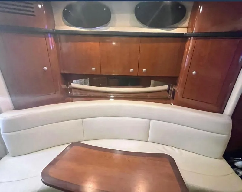 Slide: The Image of 2007 Sea Ray 320 Sundancer interior with curved seating and wooden cabinetry. - 14