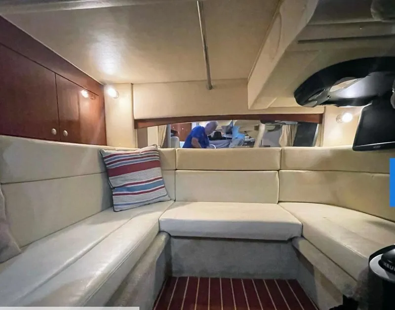 Slide: The Image of Interior of 2007 Sea Ray 320 Sundancer with cream seating and striped pillow. - 16