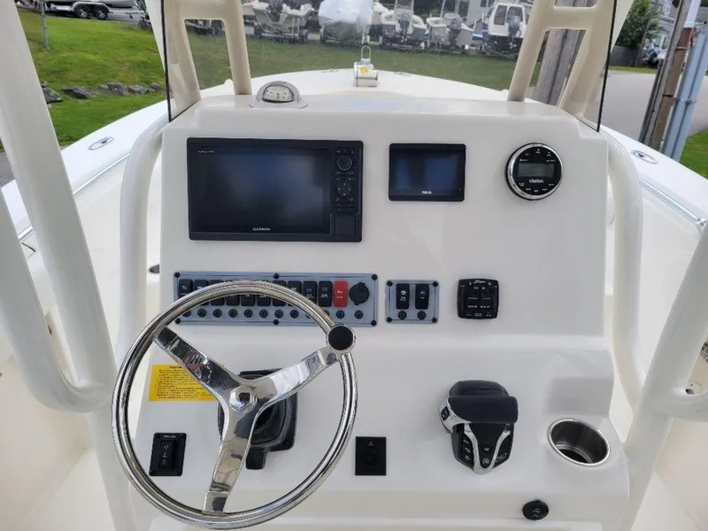 Slide: The Image of 2024 Key West 244 CC boat dashboard with steering wheel, navigation screens, and control panel. - 10