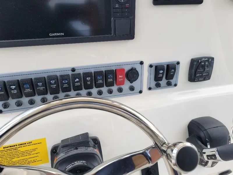 Slide: The Image of 2024 Key West 244 CC boat dashboard with Garmin navigation system and control switches. - 15