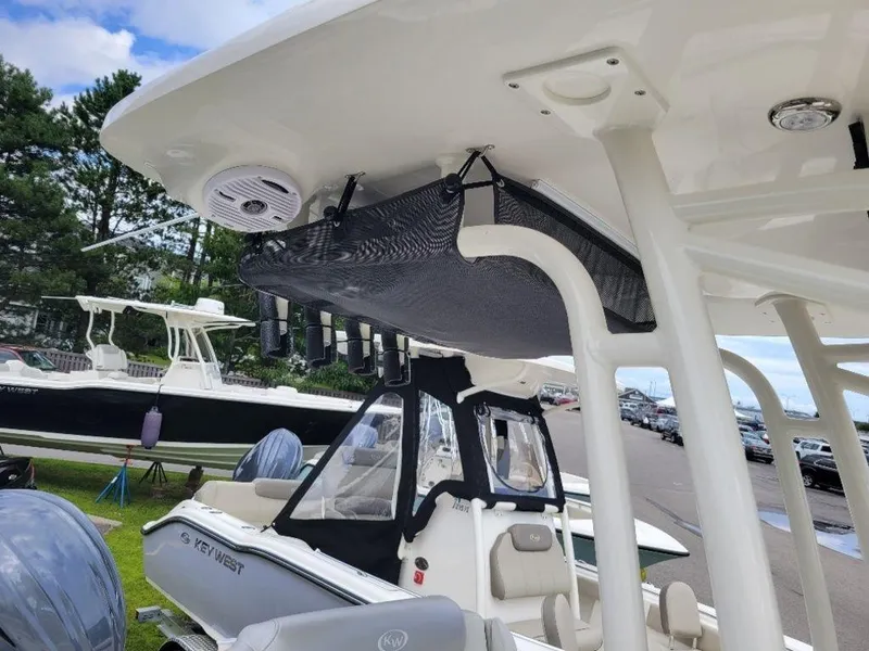 Slide: The Image of 2024 Key West 244 CC boat with T-top and storage net, docked outdoors. - 17