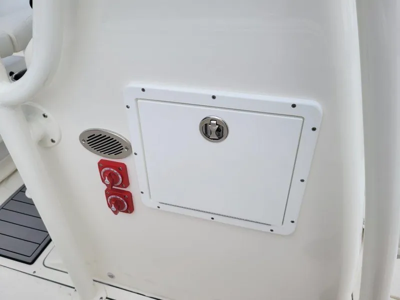 Slide: The Image of Key West 244 CC 2024 boat control panel with switches and storage compartment. - 18
