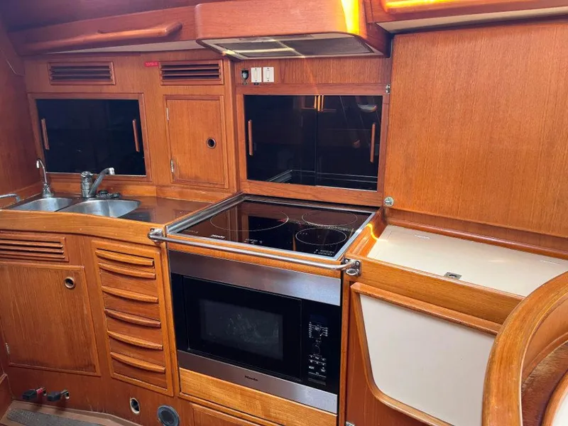 Slide: The Image of Interior of 1986 Nautor Swan 43 yacht kitchen with wooden cabinetry and modern appliances. - 25