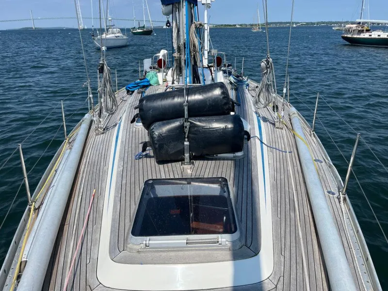 Slide: The Image of 1986 Nautor Swan 43 sailboat deck with ocean view and moored boats. - 5