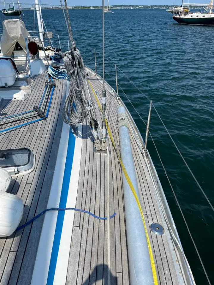 Slide: The Image of 1986 Nautor Swan 43 sailboat deck with ropes and equipment on calm water. - 6