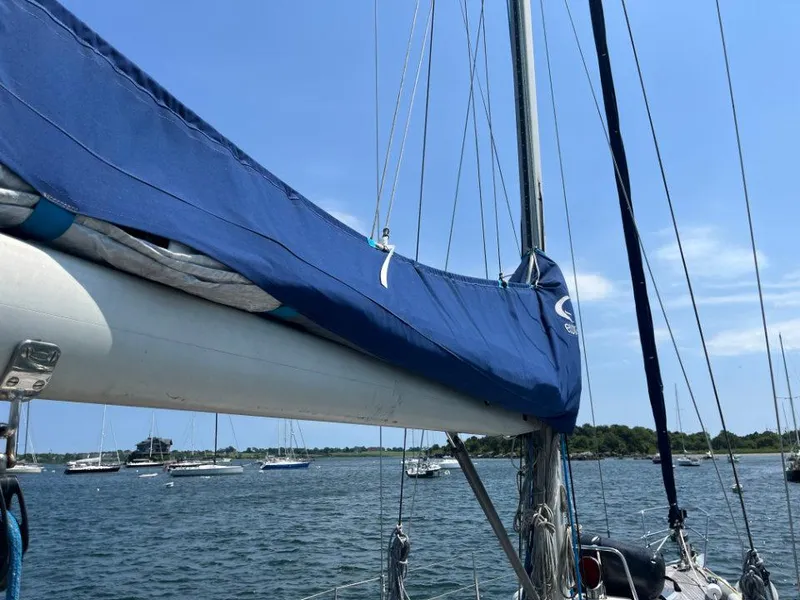 Slide: The Image of Sailboat Nautor Swan 43, 1986 model, with blue sail cover on calm waters. - 8