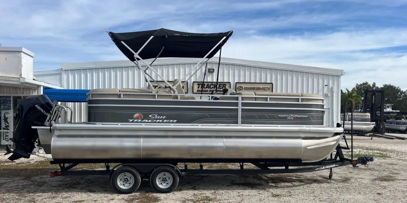 The Image of 2024 Sun Tracker Party Barge 22 XP3 pontoon boat on trailer, outdoor display. - 0