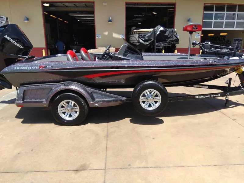 The Image of 2024 Ranger Z518 boat on trailer in showroom, featuring sleek design and red accents. - 0