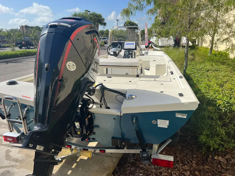Slide: The Image of 2024 Ranger RB190 boat with outboard motor on trailer, parked outdoors. - 4
