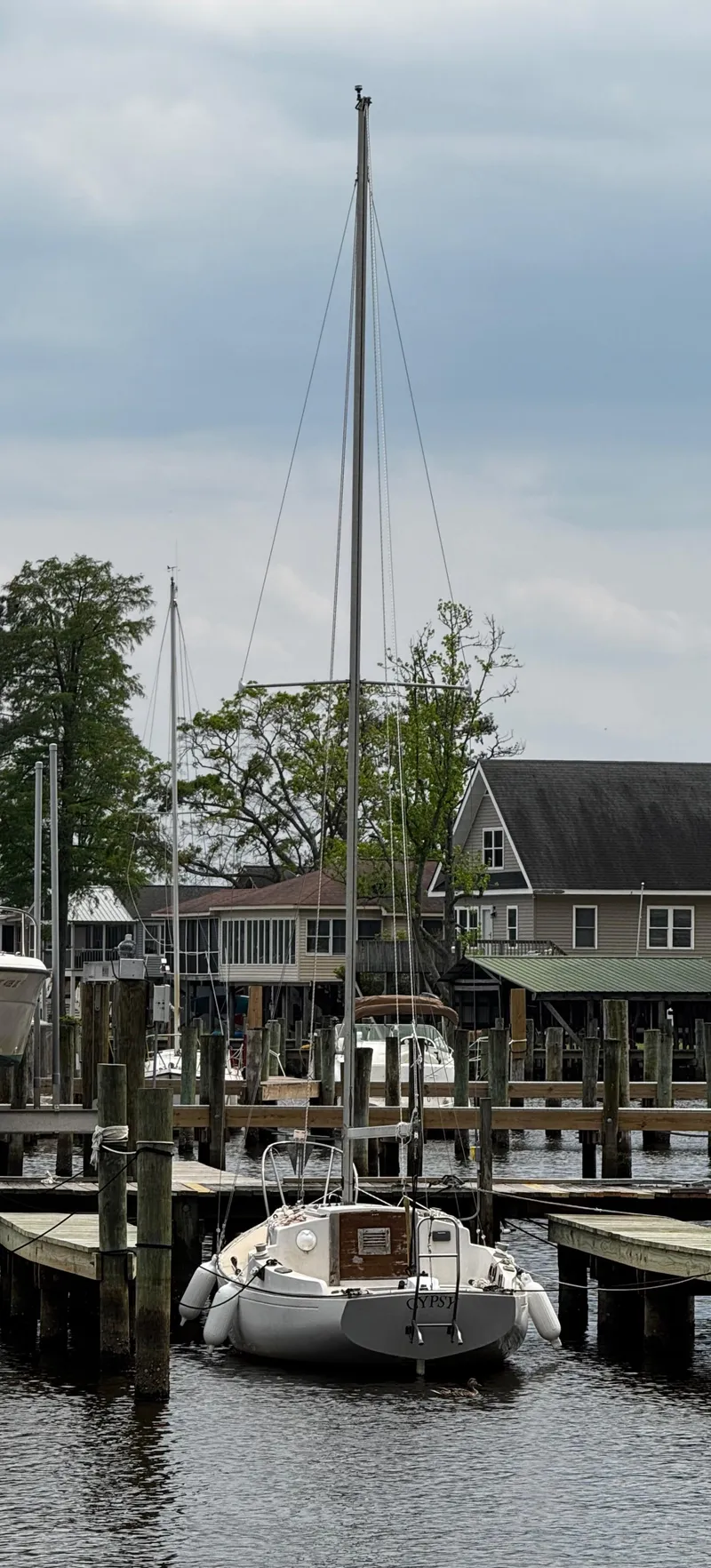 Slide: The Image of 1982 Alberg 22 sailboat docked at a marina under cloudy skies. - 13