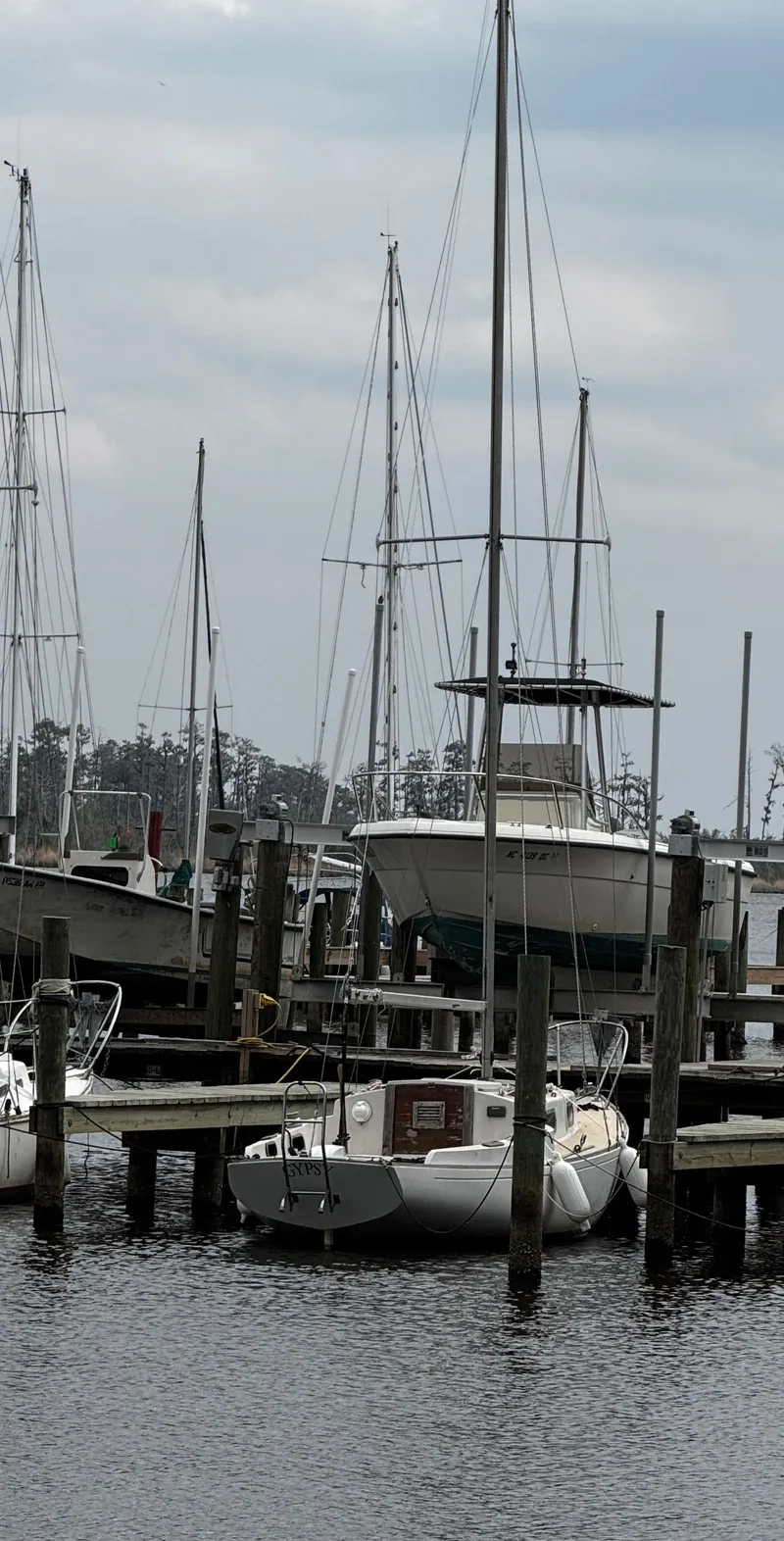 Slide: The Image of 1982 Alberg 22 sailboat docked at a marina with other boats. - 14