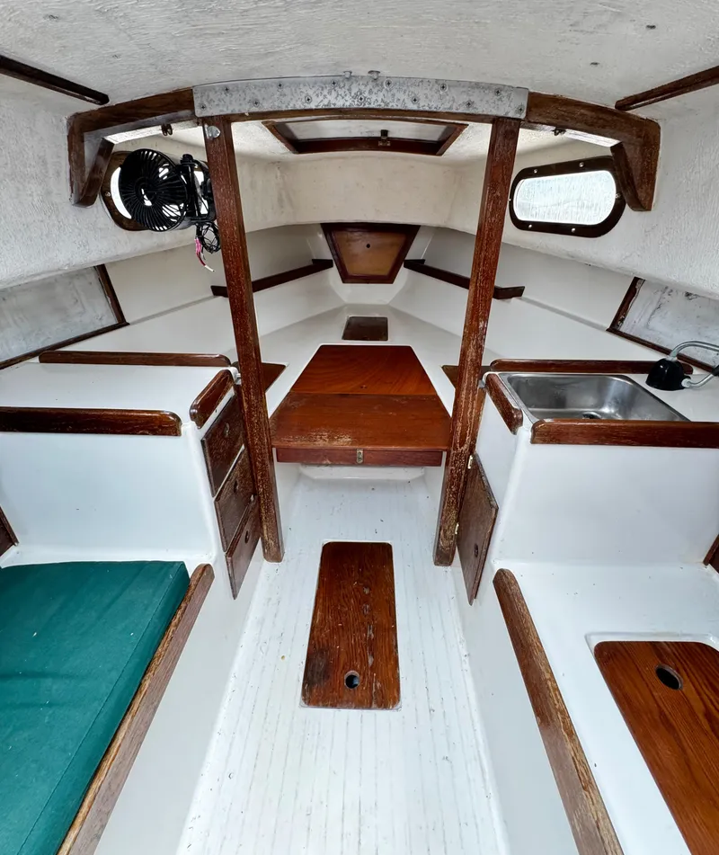 Slide: The Image of Interior of a 1982 Alberg 22 sailboat, featuring wood accents and compact cabin layout. - 30