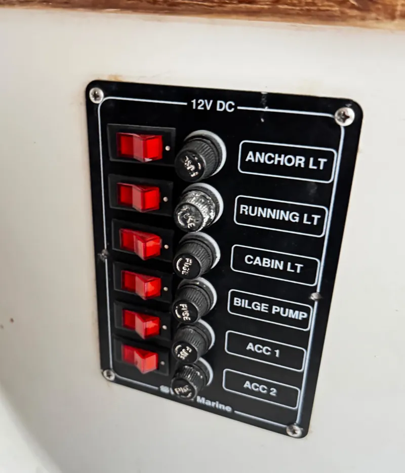Slide: The Image of 1982 Alberg 22 boat control panel with switches for lights and bilge pump. - 32