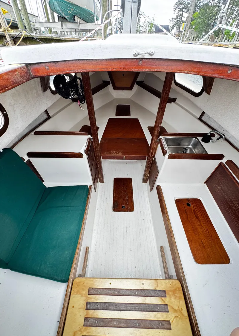 Slide: The Image of 1982 Alberg 22 sailboat interior with wood accents and green seating. - 34