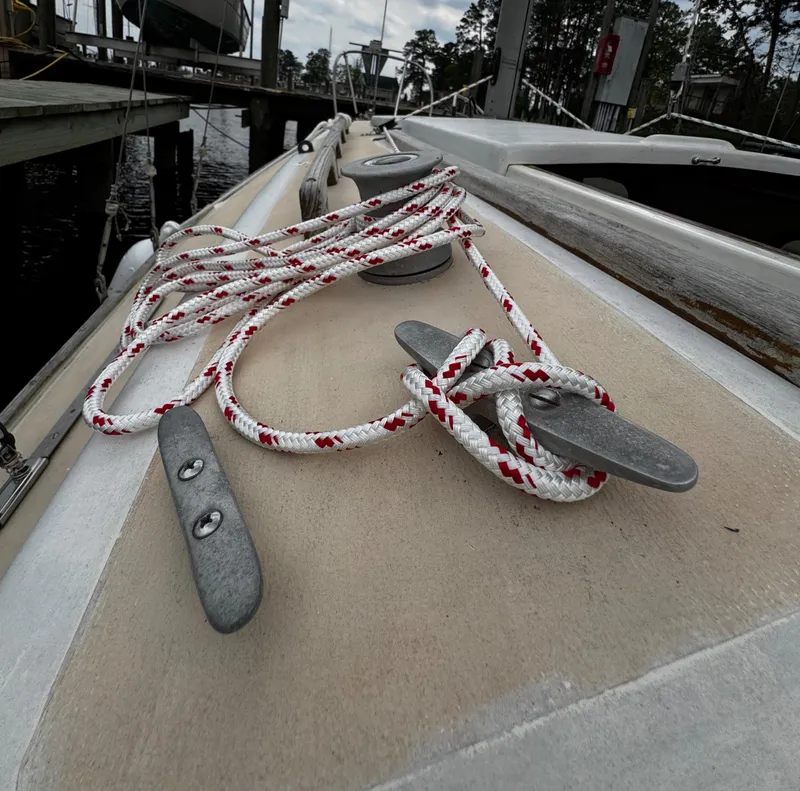 Slide: The Image of 1982 Alberg 22 sailboat deck with cleat and coiled rope at marina. - 49