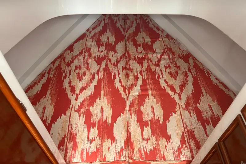Slide: The Image of 1985 Rybovich Walkaround boat interior with red and white patterned bedding. - 10